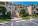 Charming condo exterior with brick stairway, neatly trimmed bushes, and two designated parking spots at 4489 Longmeadow # 74, Sarasota, FL 34235
