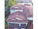 Aerial view of a residence showcasing its red-tiled roof and attached garage with brick driveway at 4622 Grand Lakeside Dr, Palm Harbor, FL 34684