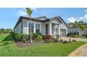 Charming single-story home with a well-manicured lawn, landscaped garden, and inviting covered entrance at 4725 Antrim Dr, Sarasota, FL 34240