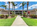 Beautifully landscaped condo building with lush greenery and a welcoming pathway at 5320 Hyland Hills Ave # 2214, Sarasota, FL 34241