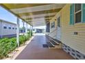 Covered patio entrance featuring a well-maintained pathway, complemented by adjacent greenery and nearby homes at 5619 Bayshore Rd # 211, Palmetto, FL 34221