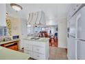 Cozy kitchen with a central island cooktop, white cabinets, and adjoining dining and living areas at 5619 Bayshore Rd # 211, Palmetto, FL 34221