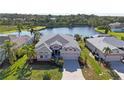 Lovely single-Gathering home features lush landscaping, a paved driveway, and serene lake views at 6311 Sturbridge Ct, Sarasota, FL 34238