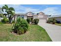 Inviting single-Gathering home with lush greenery, a paved driveway, and a two-car garage at 6311 Sturbridge Ct, Sarasota, FL 34238