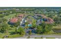 Beautiful aerial view of the condo community featuring a pool, tennis court, and lush landscaping at 6501 Stone River Rd # 304, Bradenton, FL 34203