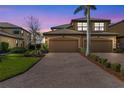 Charming two-story townhome featuring a tile roof, brick driveway, and a two-car garage at 6618 Grand Estuary Trl # 101, Bradenton, FL 34212
