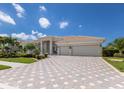 Attractive home with a three-car garage and tile roof, accented by a patterned paver driveway and manicured landscaping at 7031 Scrub Jay Dr, Sarasota, FL 34241
