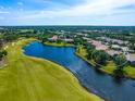 Picturesque aerial view of a home nestled amidst lush greenery, a tranquil lake, and a well-maintained golf course at 7229 Lake Forest Gln, Lakewood Ranch, FL 34202