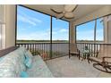 Cozy screened porch with comfortable seating, ceiling fan, and scenic waterfront views at 7705 Grand Estuary Trl # 206, Bradenton, FL 34212