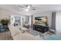 Bright living room features ceiling fan, modern entertainment center with fireplace, and view of office at 8225 Drew St, Englewood, FL 34224