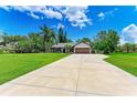 Charming home on a lush green lot with an expansive driveway and manicured lawn at 1103 134Th E St, Bradenton, FL 34212