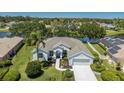 Stunning waterfront home featuring lush landscaping, a private dock, and solar panels for energy efficiency at 12005 Summer Meadow Dr, Lakewood Ranch, FL 34202