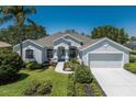 Charming single-story home featuring an attached two-car garage, manicured landscaping, and a well-maintained lawn at 12005 Summer Meadow Dr, Lakewood Ranch, FL 34202