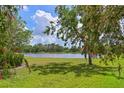 Serene backyard featuring well-maintained lawn and picturesque lake view at 15451 27Th E Ct, Parrish, FL 34219