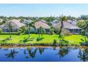 Back exterior view showing a screened in porch, lush green lawn, and a peaceful pond at 1806 85Th Nw Ct, Bradenton, FL 34209