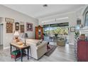 Inviting living room featuring wood-look tile flooring, a cozy seating arrangement, and view to the outdoors at 2183 Muskogee Trl, Nokomis, FL 34275