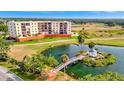 Condominium building overlooking a serene pond with gazebo and meticulously maintained green spaces at 2311 14Th W Ave # 208, Palmetto, FL 34221