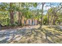 Charming home with distinctive turquoise door, white columns, and a small balcony surrounded by lush trees at 2315 Mcclellan Pkwy, Sarasota, FL 34239