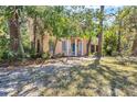 Home's exterior featuring a turquoise front door, white columns, a balcony, and natural landscaping at 2315 Mcclellan Pkwy, Sarasota, FL 34239