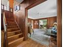 Inviting living room featuring hardwood floors, wood paneling, and an open staircase at 2315 Mcclellan Pkwy, Sarasota, FL 34239