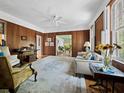 Bright living room with wood paneling, light rug, and views into the sunroom at 2315 Mcclellan Pkwy, Sarasota, FL 34239