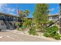 Two-story condo with a landscaped courtyard, featuring vibrant green trees and a relaxing outdoor seating area at 236 Harbor S Dr # 205, Venice, FL 34285