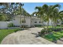 Beautiful single-story house with mature landscaping and a curved driveway under a clear, sunny sky at 322 35Th Ne Ave, St Petersburg, FL 33704