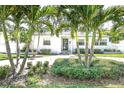 Beautiful, single-story home featuring a well-manicured front yard with mature palm trees and lush landscaping at 322 35Th Ne Ave, St Petersburg, FL 33704