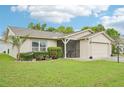 Inviting single-story home with screened entry, a well-kept lawn, and mature landscaping creating a welcoming atmosphere at 338 Indian Key Way # 111, Englewood, FL 34223