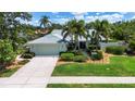 Charming single-story home with lush landscaping, palm trees, and a two-car garage at 3667 Country Place Blvd, Sarasota, FL 34233