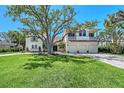 Inviting two-story home boasts a manicured lawn and a spacious three-car garage at 404 S Shore Dr, Sarasota, FL 34234