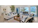 Elegant living room with stylish furniture, open to an outdoor dining area and stunning waterfront views at 404 S Shore Dr, Sarasota, FL 34234