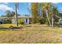 Modest home with a simple lawn, mature trees, and minimal landscaping at 440 Redwood Rd, Venice, FL 34293