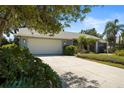 Charming home featuring a two-car garage and a well-maintained lawn with beautiful landscaping at 4449 Greenfield Ave, Sarasota, FL 34233