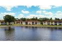 Condo complex exterior view by the lake with lovely landscape and blue sky at 4454 Narraganset Trl # 94A, Sarasota, FL 34233