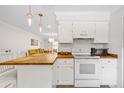 Kitchen with white cabinets, butcher block counters, and stainless steel appliances at 4454 Narraganset Trl # 94A, Sarasota, FL 34233