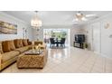 Bright living room featuring neutral tones, tile floors, chandelier, and adjacent dining area with lake views at 4454 Narraganset Trl # 94A, Sarasota, FL 34233