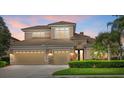 Charming two-story home featuring a three-car garage and beautifully manicured landscaping against a vibrant twilight sky at 6532 Coopers Hawk Ct, Lakewood Ranch, FL 34202