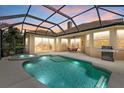 Gorgeous screened-in pool and spa area with outdoor dining and grill, perfect for entertaining at 6532 Coopers Hawk Ct, Lakewood Ranch, FL 34202