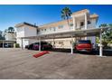 Exterior of condo building with covered parking for residents and guests and tropical landscaping at 6727 Midnight Pass Rd # 202A, Sarasota, FL 34242