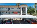 Exterior of condo building with covered parking for residents and guests and tropical landscaping at 6727 Midnight Pass Rd # 202A, Sarasota, FL 34242