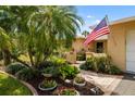 Beautifully landscaped front yard featuring lush greenery, flower pots, and a brick walkway at 6940 W Country Club N Dr # V-77, Sarasota, FL 34243