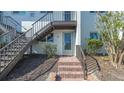 Charming condo exterior showing unit's entryway with stairway and updated neutral paint at 6951 Gulf Of Mexico Dr # 14, Longboat Key, FL 34228