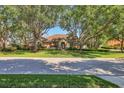 Charming one-story home with a tile roof, well-manicured lawn, and mature trees at 7441 Myrica Dr, Sarasota, FL 34241