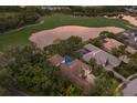 A captivating aerial view of the beautiful home showcasing its private pool, stunning landscaping, and lake views at 7532 Greystone St, Lakewood Ranch, FL 34202