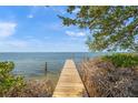 Private wooden dock leading out into the bay with foliage surrounding the shore at 7620 Westmoreland Dr, Sarasota, FL 34243