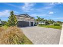 Desirable home featuring a stone facade, a two-car garage, and well-maintained landscaping at 8033 Grande Shores Dr, Sarasota, FL 34240
