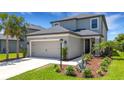 Close up exterior view showing a two-car garage and a manicured lawn at 8355 Velda Trl, Sarasota, FL 34241