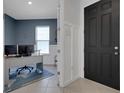 Home office featuring blue accent wall, a modern desk, and a view through the door to the entry at 8355 Velda Trl, Sarasota, FL 34241