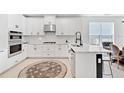 Bright kitchen featuring white cabinetry, granite countertops, stainless steel appliances, and modern fixtures at 8355 Velda Trl, Sarasota, FL 34241